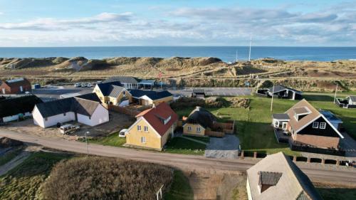 a small town with houses and the ocean at Strandhuset in Agger