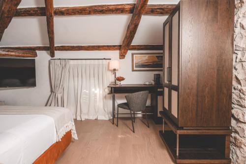 a bedroom with a bed and a desk and a bed and a table at Boutique Hotel San Rocco in Brtonigla