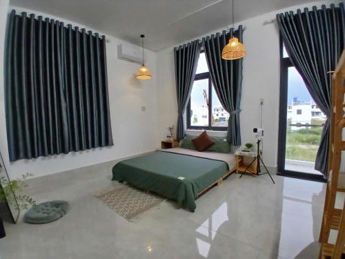 a bedroom with a bed in a room with windows at Nhi Homestay Rạch Giá in Rach Gia