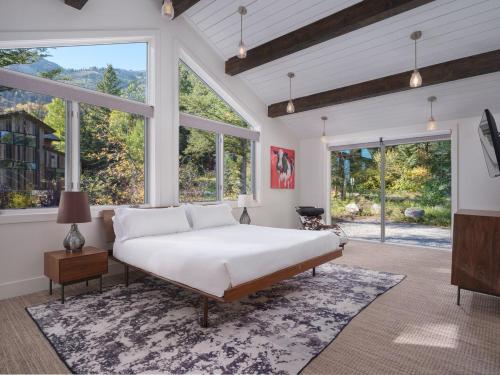 a bedroom with a large bed and large windows at RMR: Montreux House in Teton Village in Teton Village