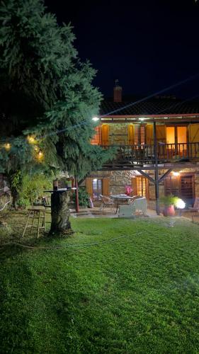a house with a tree in the yard at night at Villa Tzeni Palios Panteleimon in Panteleímon