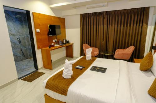 a hotel room with a bed and a television at Hotel Sterling Executive in Navi Mumbai