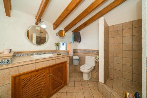 a bathroom with a toilet and a sink and a mirror at Can Lluna in Tárbena