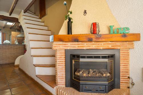 a fireplace in a living room with a staircase at Can Lluna in Tárbena