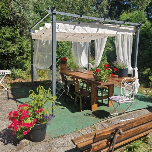 a wooden table under a white canopy with potted plants at Willa Marysin in Maków Podhalański