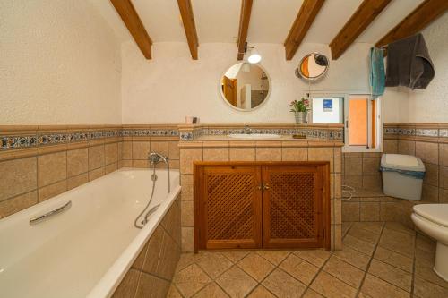 a bathroom with a tub and a toilet and a sink at Can Lluna in Tárbena
