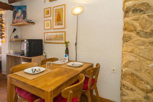 a dining room table with chairs and a television at Can Lluna in Tárbena
