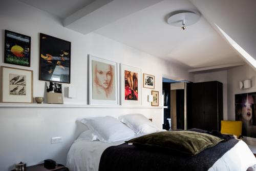 Schlafzimmer mit einem Bett mit Bildern an der Wand in der Unterkunft Le Pigalle, a Member of Design Hotels in Paris