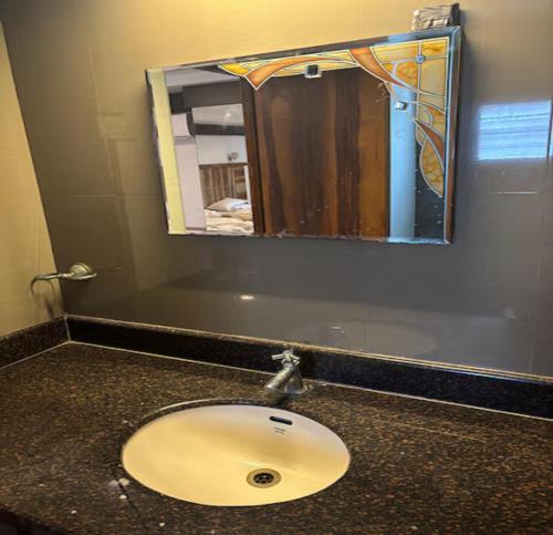 a bathroom counter with a sink and a mirror at Eastin Park in Navalur