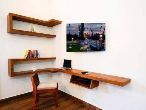 a room with a desk and a computer on a wall at Bhuthanakadu Retreat Homestay Chikamagalur in Mudigere
