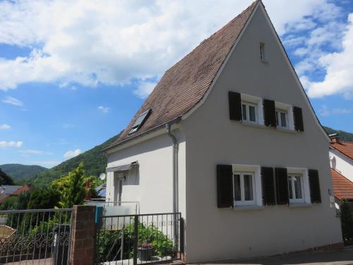 a white house with black windows and a fence at Ferienhaus Trifels in Annweiler am Trifels