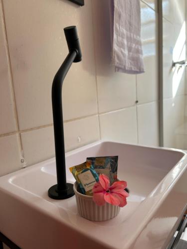 a bathroom sink with a black faucet and a cupcake at Hari Eco Pousada in Brumadinho