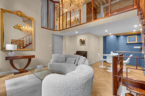 a living room with a couch and a table at Les Relais du Capitole - Appartements d'hôtes in Toulouse