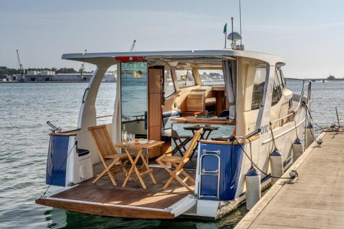 un barco con mesa y sillas en el muelle en Rosé Dream Boat by Portugal Active, en Viana do Castelo
