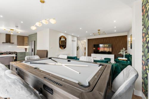 a pool table in a living room with a billiard at Stylish group retreat with garden, games & parking in West London in Staines