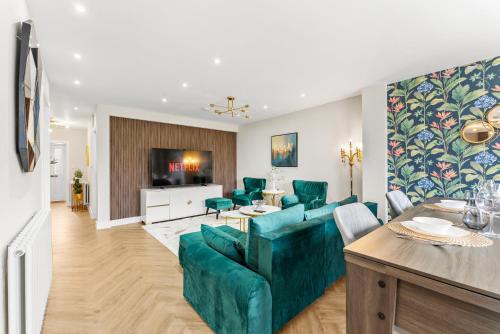 a living room with a green couch and a table at Stylish group retreat with garden, games & parking in West London in Staines