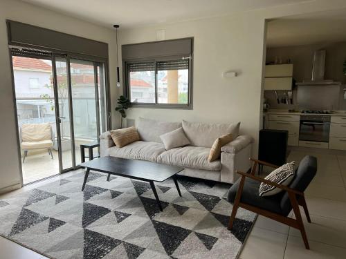 a living room with a couch and a table at The Urban Retreat by IsrApart in Ra‘ananna