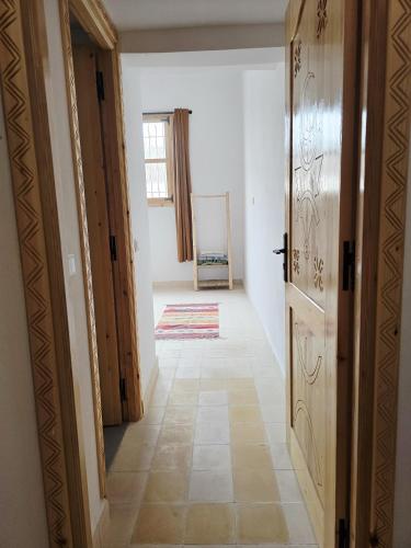 an empty hallway with a door and a room at Tasga Guest House in Tamraght Oufella