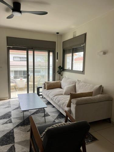 a living room with a couch and a table at The Urban Retreat by IsrApart in Ra‘ananna