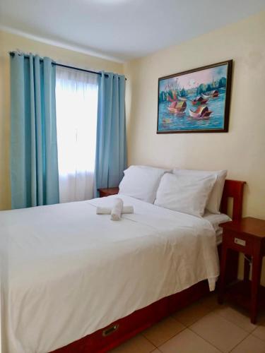 a bedroom with a large white bed with a window at DaLei 1-319 Sleeps 8pax at Marina Spatial Condominium in Dumaguete City in Dumaguete