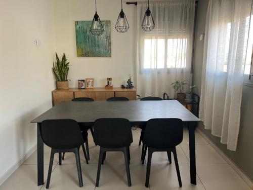 a dining room with a table and chairs at The Urban Retreat by IsrApart in Ra‘ananna