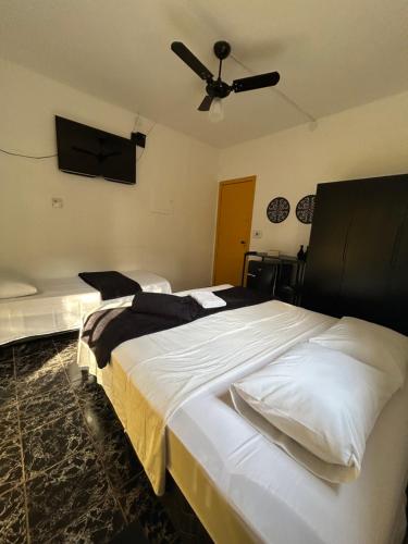 a bedroom with two beds and a ceiling fan at Hari Eco Pousada in Brumadinho