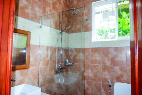 a bathroom with a shower and a toilet and a sink at VanVei Villas and Apartments in Dar es Salaam