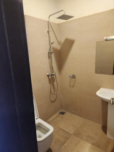 a bathroom with a shower with a toilet and a sink at Résidence AMIRAL in Niamey