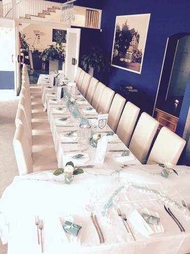 a long table with white tables and white chairs at Hotel Sittardsberg in Duisburg