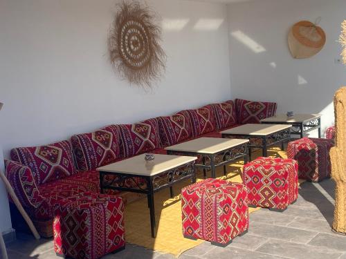 a living room with a couch and tables and chairs at Hôtel Les Remparts in Azemmour