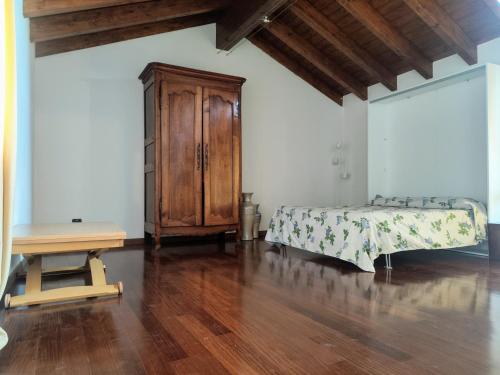 PusianoにあるDelizioso appartamento al lagoのベッドと木製のキャビネットのある寝室