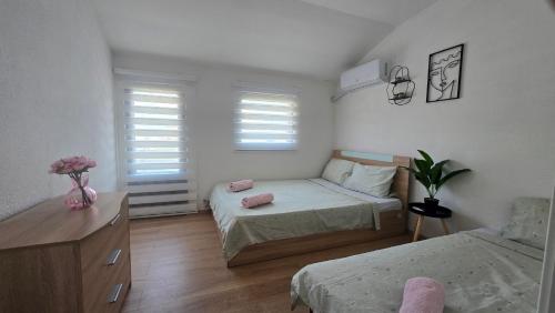 una piccola camera da letto con due letti e una cassettiera di Property Sim-Vlae a Skopje