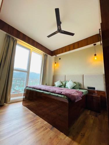 a bedroom with a bed with a ceiling fan at Meralya Woods - In the Luxe of Nature in Solan