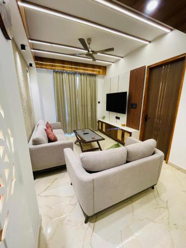 a living room with two couches and a tv at Meralya Woods - In the Luxe of Nature in Solan