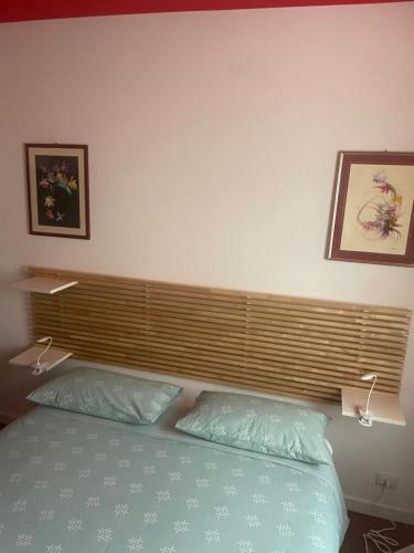 a bedroom with a bed and two pictures on the wall at COZY Place 26 in Vercelli