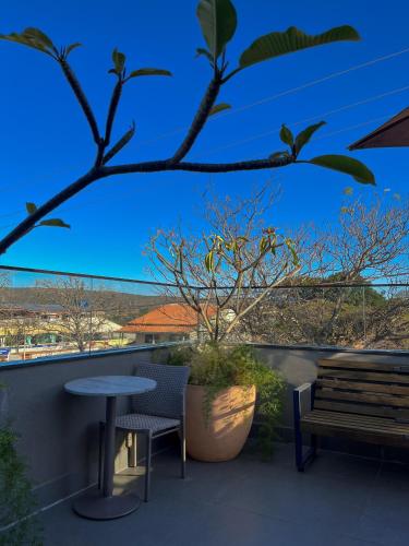 a table and a bench on a balcony with a view at Pousada Flor de Anis in Alto Paraíso de Goiás