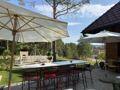 a table and chairs with umbrellas on a patio at Angelina Apart Hotel&Spa in Divčibare