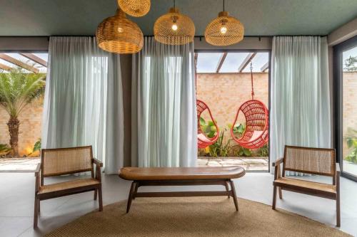 two chairs and a table in a room with windows at Pousada Flor de Anis in Alto Paraíso de Goiás
