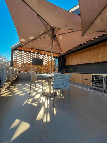 a patio with a table and chairs on a roof at Pousada Flor de Anis in Alto Paraíso de Goiás