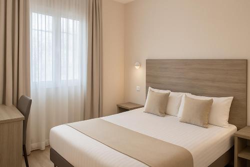 a hotel room with a large bed and a window at Thoiry Étoile Lodge in Thoiry