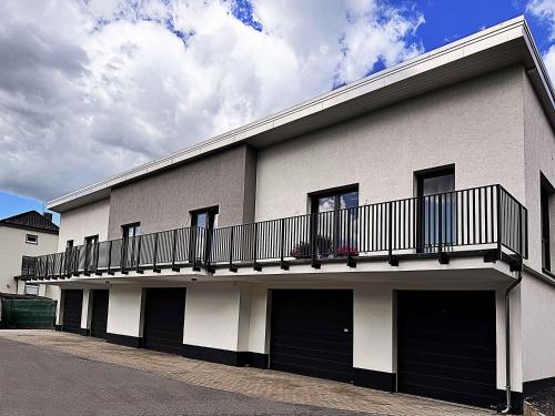 a white building with a balcony on top of it at Neues Ruhrtal Apartment 2 in Wickede (Ruhr)