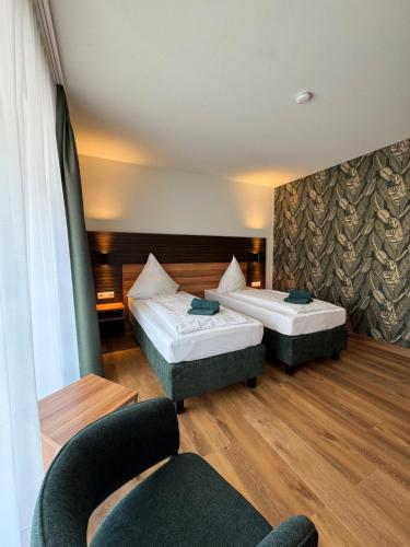 a hotel room with two beds and a couch at Hotel Sittardsberg in Duisburg