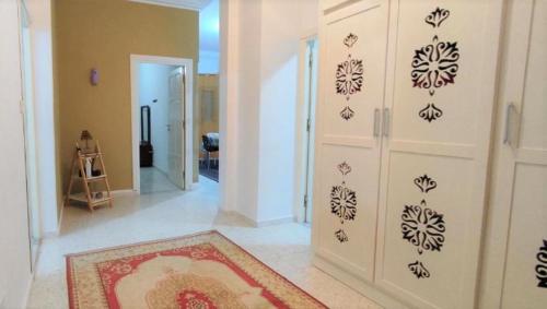a living room with a white wall with black stencils at villa mimosa avec parking intérieur in Tataouine