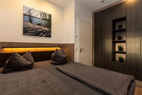 a bedroom with a large bed with pillows on it at Ferienhaus SUNSET am Mühlfeldsee in Löbnitz