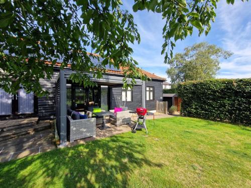 a backyard with a house with a lawn at Swift Host - Owl Barn - Sleeps 2 - EV Charger - Pet Friendly in Loddon