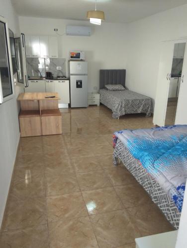 a large room with two beds and a kitchen at Le petit Mimosa - City Center in Tataouine