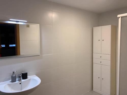 ein weißes Badezimmer mit Waschbecken und Spiegel in der Unterkunft Attenery in Las Palmas de Gran Canaria