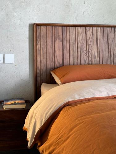 a bedroom with a bed with a wooden head board at Dali Healing Yard 喜洲禾隐星登 in Dali