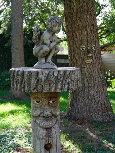 a statue of a child on top of a tree stump at Hametner mit Innviertlerhaus mit Thermenzugang in Bad Hall
