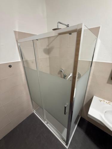 a glass shower in a bathroom with a sink at Sc Residence Parma in Parma